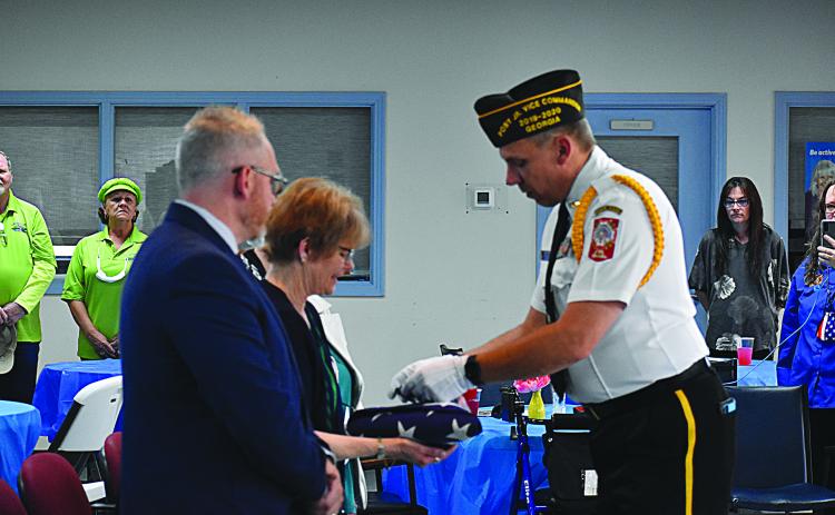 Sharon Krefft is presented with an American Flag, along with a buddy poppy and a three-shell casing from the three-round volley in honor of her husband Calvin at his celebration of life ceremony. VFW member Jim Morgan presented her with the gifts.
