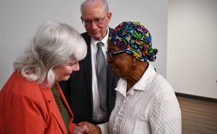 Mary Ann Wiley (left) confers with Betty Gober after an event honoring her and her husband Dr. Bob Wiley (background) on Thursday. MATTHEW OSBORNE/Staff