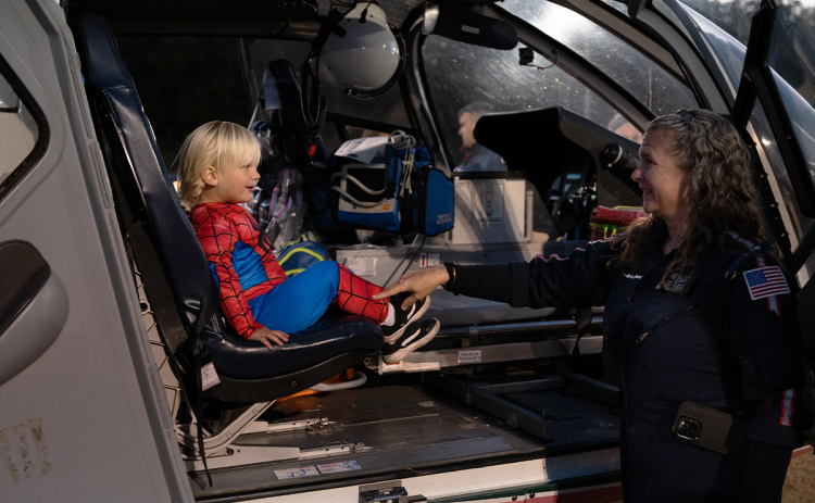 Briggs Schiflett, dressed as Spider-Man, gets a tour of the AirLife helicopter by Flight Paramedic Jennifer Davis at the E-911 halloween festival on Oct. 20. ZACH TAYLOR/Special