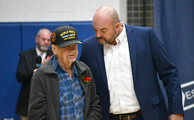 Habersham County Superintendent Matthew Cooper (right) recognizes Garnett Burrell, a World War II veteran, at Monday’s veterans program at Wilbanks Middle School. JOHN DILLS/Staff