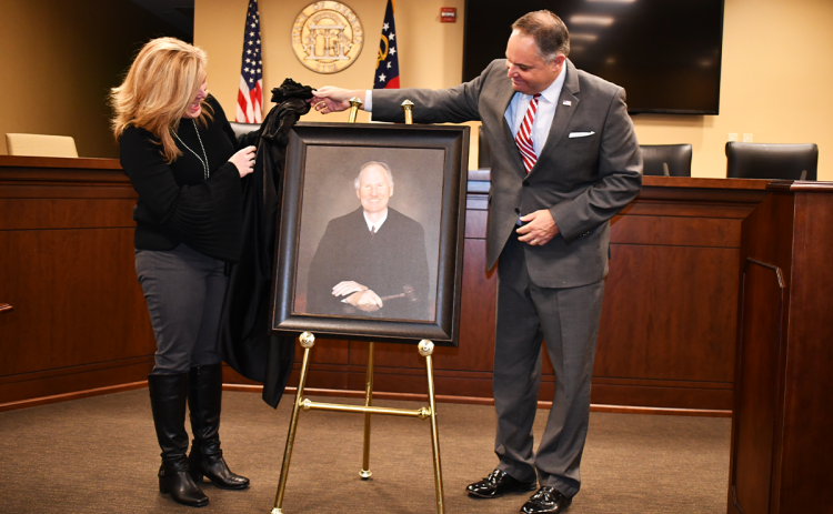 Boen Butterworth Nutting and James Butterworth unveil a portrait of their father, Judge Jim Butterworth, at the Habersham County Courthouse Friday afternoon. The portrait will hang in the magistrate courtroom. MATTHEW OSBORNE/Staff