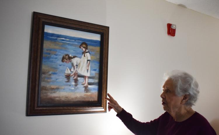 Magnolia Hills resident Mary Lou Martin admires a painting in her room, reminding her of her grandchildren. EMMA MARTI/Staff