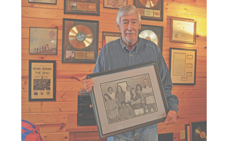 Gary Donehoo holds a photo of him, Alan Walden and Eddie Floyd with Lynyrd Skynyrd in front of his wall of memorabilia of the band. “They were all good guys,” Donehoo said. “The original band, they were hungry, they all came from west Jacksonville… they knew the only way out was education, music or sports.” SAMANTHA SINCLAIR/White County News