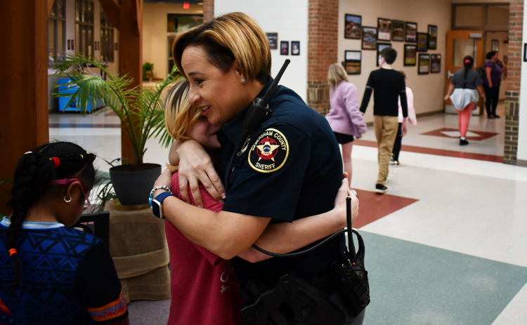 Habersham County Resource Officer Evaleez Gonzalez gets a hug from a student at Fairview Elementary School on Tuesday morning. JOHN DILLS/Staff