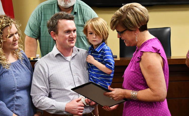 Chandler Franklin, 4, is honored by County Manager Alicia Vaughn along with his parents Clayton and Allyson, at Monday’s Board of Commissioners meeting. Commissioner Bruce Palmer and the rest of the board thanked the young man for his alertness to a county utility malfunction. MATTHEW OSBORNE/Staff