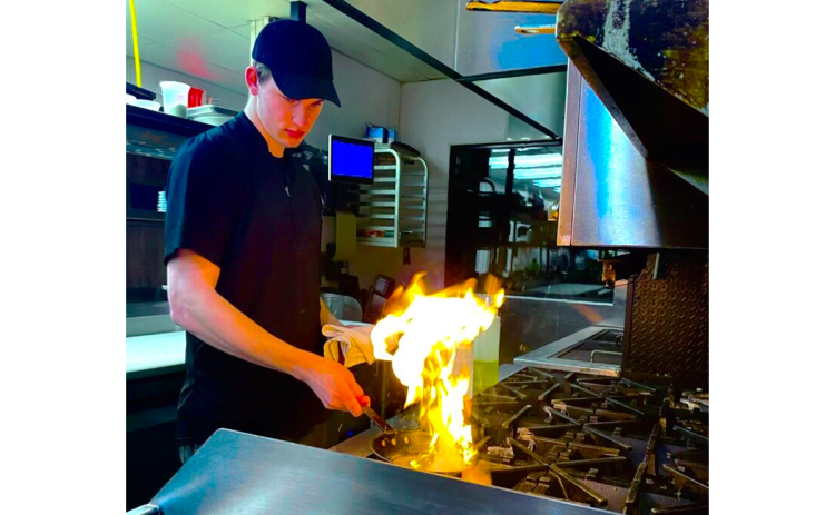 Jace Reeder gets his dish going during one of his shifts at Community Brew & Tap in Cornelia. Reeder also cooks at Fenders Diner. SUBMITTED