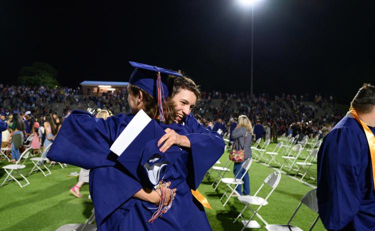 Habersham Central seniors Dan Griswold and Cody Thomas hug while parents and siblings rush the field to find their graduates. ZACH TAYLOR/Special
