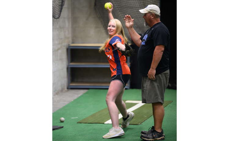 Nick Denton, a pitching and hitting instructor at Velo Factory, instructs Ava Buffington (left) to not hit his arm in a cross-body pitching drill for changeups. ZACH TAYLOR/Special