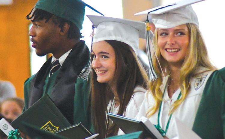 With fellow graduate Frankey Moree, Tallulah Falls seniors Meredith Morris and Madeline Mullis share a laugh during the May 19 ceremony. ENOCH AUTRY/CNI News Service