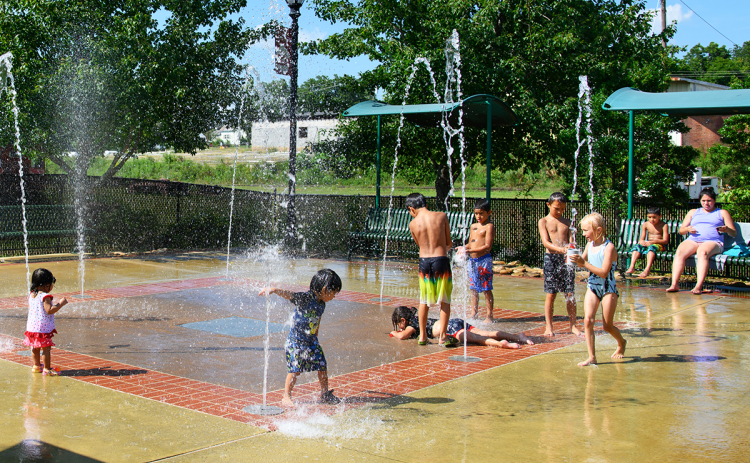 Parents watch as a group of kids play together in the Cornelia Splash Pad, which provides a great way to cool off on hot summer days. ZACH TAYLOR/Special