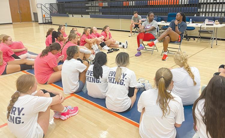 Volleyball professionals Lauren Ford and Santita Ebangwese (seated at right) impart wisdom to the campers.