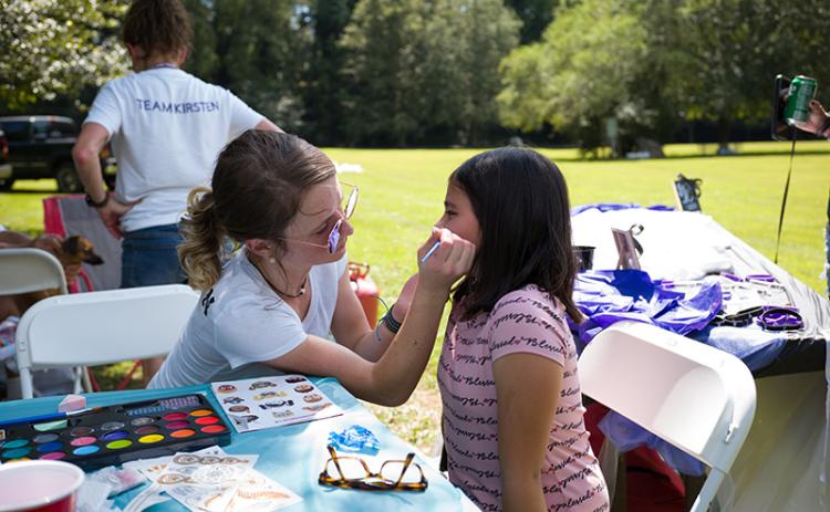 Kirsten Stephens paints a cat on Jeansly Contreras at the Children Affected by Addiction event in Pitts Park on Saturday. ZACH TAYLOR/Special