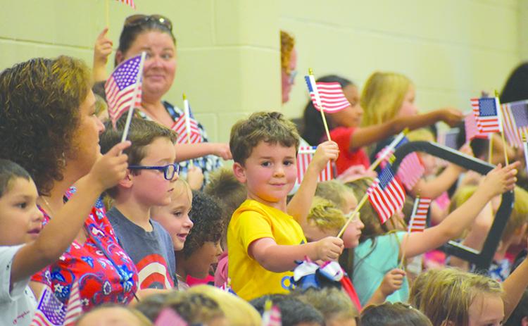 McCoy Malcom (center) joins his classmates in waving Old Glory to celebrate the Hometown Heroes at Fairview Elementary on Monday afternoon. MATTHEW OSBORNE/Staff