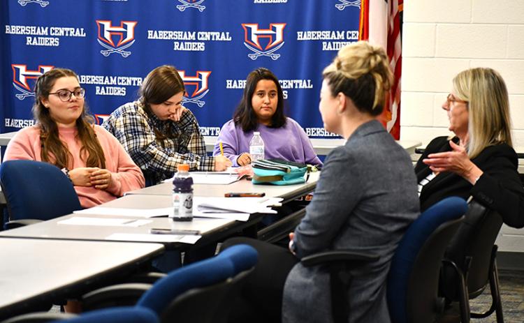 From left, Habersham Central High School students Sarah Wheeler, Brook Scherer, and McKenzie Smith listen and take notes while Attorneys Rebecca James, left, and Suzanne Boykin, right, teach them about objections. JULIANNE AKERS/Staff