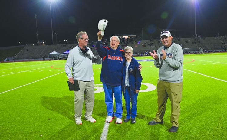 Glenn Jones and his wife Susan acknowledge the Raider crowd Friday night at halftime after being honored for his 46 years of public address announcing at the school. They are joined by athletic director Geep Cunningham (left) and Principal Dr. Jonathan Stribling. TOM ASKEW/Special