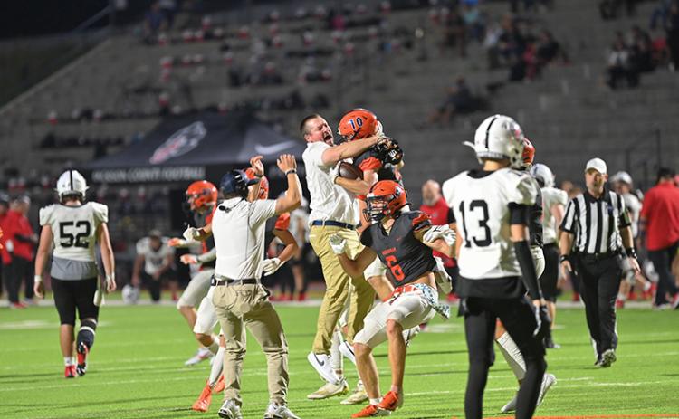Habersham Central assistant coach Brandon Worley embraces Hayden Gailey (10) in the pandemonium following Gailey’s game clinching interception in double overtime on Friday night against Jackson County. TOM ASKEW/Special