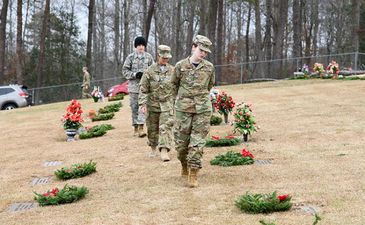 At Saturday’s Wreaths Across America ceremony at the VFW Memorial Park, Josslyn Webber, Zaelice Phasavang and Gabriel Morales ensure each veteran has a wreath placed on their headstone after the ceremony. ZACH TAYLOR/Special