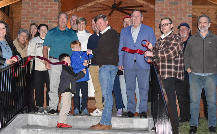 Hunter Harkness and Finn Durden cut the ribbon at Demorest’s new restroom and shelter pavilion in Demorest Springs Park on Wednesday night. Also in attendance (from left) Chamber of Commerce Director Ellie Van Doornum, Lynn Percy, Rachel Pleasant, Brooke Terilli, City Manager Mark Musselwhite, Keith Andrews, Councilman Donnie Bennett, Mayor Jerry Harkness, Councilman Shawn Allen, County Vice-Chairman Bruce Harkness, Randall Roy Fry, Demorest Fire Chief Jerry Palmer and Guy Ramos. MATTHEW OSBORNE/Staff 