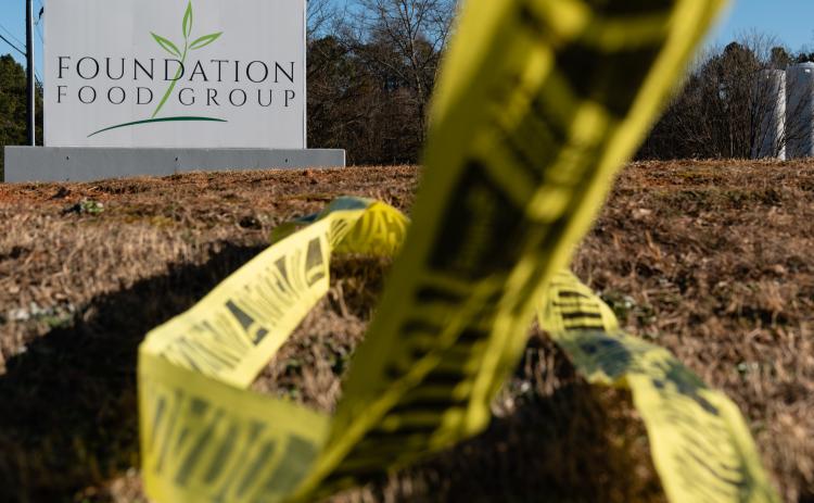 Crime Scene tape is strewn across the ground at Foundation Food Group in Gainesville, Georgia. Credit/ Getty Images