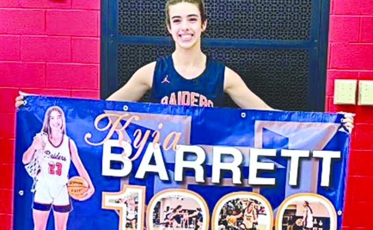 Kyia Barrett shows off her banner commemorating her 1,000th point. SUBMITTED