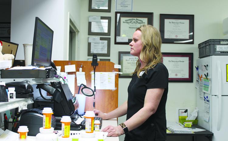 Tim’s Pharmacy owner Kim Kaminski works to check prescription statuses  before closing for the day. BRIAN WELLMEIER/Special 