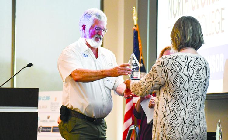 Joe Hatfield (left) accepts the new Mountain Mover Award from United Way Director Candice Holcomb at the United Way breakfast Thursday morning at North Georgia Technical College. JULIANNE AKERS/Special